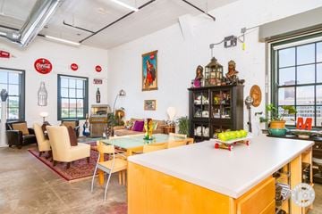 Des Moines apartment for rent - A kitchen with a yellow island and a dining table with chairs.